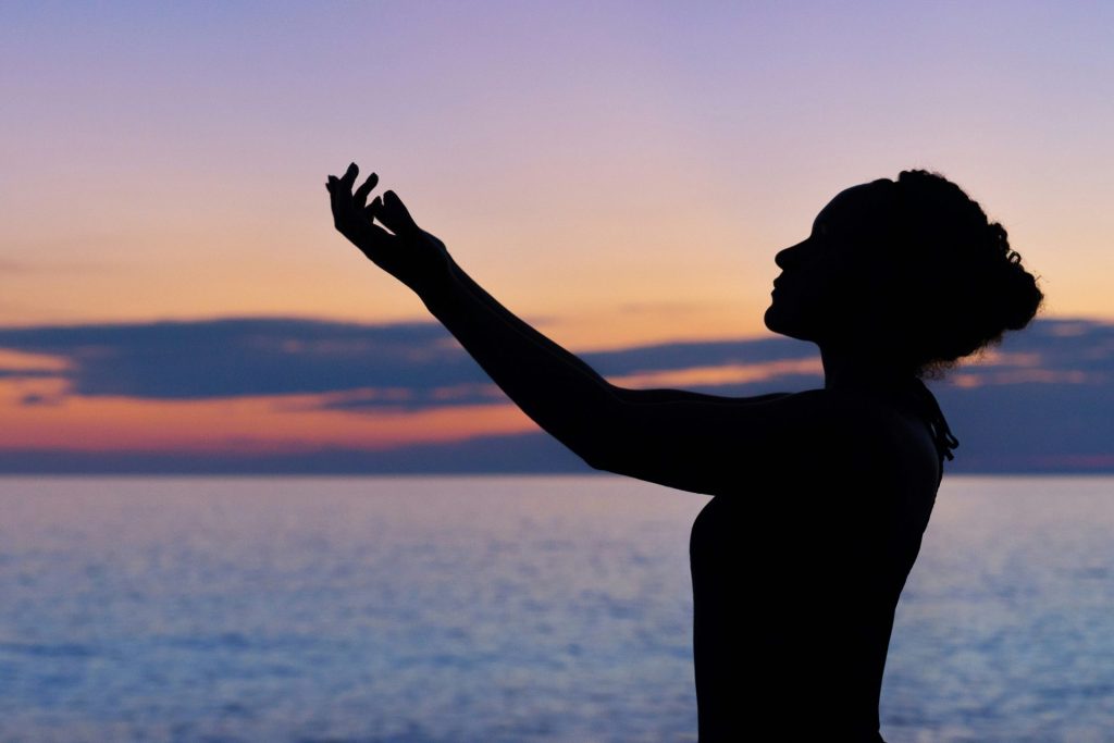 silhouette d'une femme levant la main droite